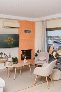 a living room with a fireplace and a table and chairs at Glyfada Cove Apartments-Ostria in Athens