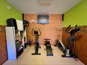 a gym with two exercise bikes and a tv on the wall at Pokoje U SABI in Wisła