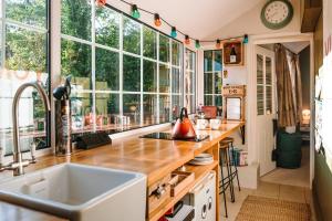 a kitchen with a sink and some windows at River Cottage at Old Post Office in Bardon Mill