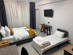 een slaapkamer met 2 bedden en een tafel en een televisie bij Thess Living Suites in Thessaloniki
