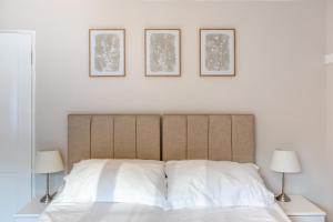 una camera da letto con un letto e tre quadri sul muro di 2 Bed in Sticklepath oc-l33312 a Sticklepath