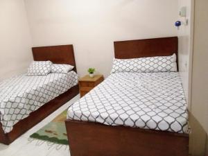 a bedroom with two beds with white sheets at Nile palace in Jazīrat Aswān