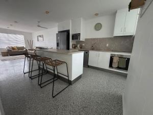 a kitchen with a counter and stools in a room at Large Earthy toned Apartment in Ross River