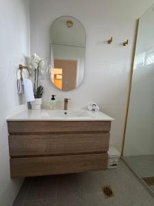 a bathroom with a sink and a mirror at Large Earthy toned Apartment in Ross River +45 photos