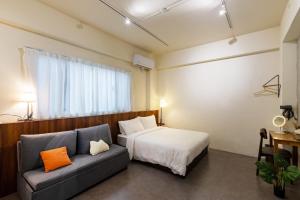 una camera da letto con un letto e un divano di 木子寓所 Moozhouse a Magong