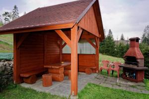 a wooden play house with a fireplace and two chairs at Pokoje U SABI in Wisła