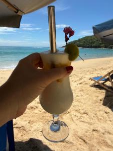 Flat Trindade في ترينيداد: يد مسكة مشروب على الشاطئ