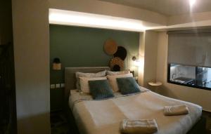 a bedroom with a large bed with a green wall at Φεγγαρόπετρα ΓΑΙΟΦΩΣ in Kalívia
