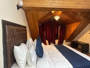 una camera da letto con un letto con cuscini bianchi e blu di The Blue Park By OSCAR a Manāli