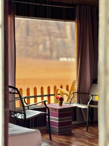 a room with a window with a table and chairs at Mira Bubble Luxury Camp in Wadi Rum