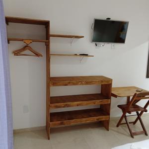 a room with a desk and a tv on a wall at Hawaii Flats in São Miguel do Gostoso