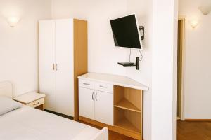a bedroom with a bed and a tv on the wall at Better place in Bečići