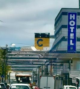 een drukke straat met auto's geparkeerd voor een gebouw bij Hotel Itajaí Tur - Itajaí Navegantes in Itajaí