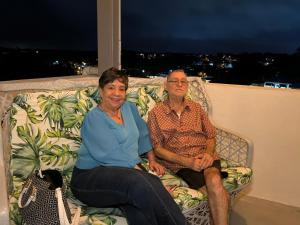 a man and woman sitting on a couch on a balcony at Mi lugar de descanso in Moca +5 photos