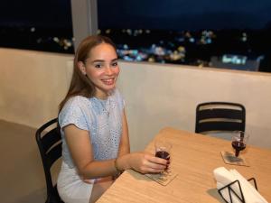 a woman sitting at a table with a glass of wine at Mi lugar de descanso in Moca