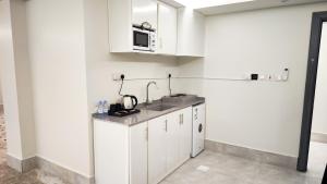 a kitchen with a sink and a microwave at نوف بلازا nouf plaza for serviced apartments in Ad Dawādimī