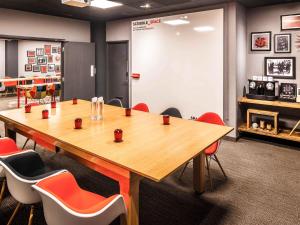 una sala conferenze con un grande tavolo e sedie in legno di ibis Birmingham Centre New Street Station Hotel a Birmingham