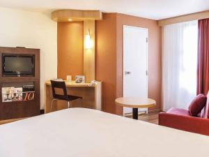 een hotelkamer met een bed, een tafel en stoelen bij ibis Poitiers Centre in Poitiers +43 foto's