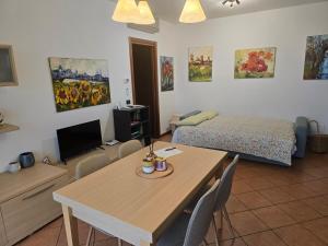 ein Schlafzimmer mit einem Tisch und einem Bett sowie einem Tisch und Stühlen in der Unterkunft Aurora's Home in Dalmine