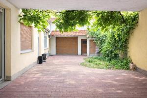 ein gemauerter Gehweg, der zu einem Gebäude mit einer Garage führt in der Unterkunft 4RENT Apartments - Monteurzimmer in Worms