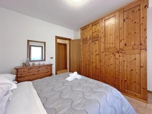 a bedroom with a large bed and wooden cabinets at BBkey Borgo Living Sutrio in Sùtrio