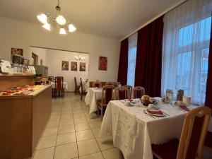 a restaurant with two tables with white table cloths at Mariazellerhof Suite 016 in Sankt Pölten +2 photos