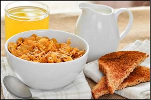 eine Schüssel Müsli mit Toast und ein Krug Orangensaft in der Unterkunft Elm Tree Motel in Warrnambool