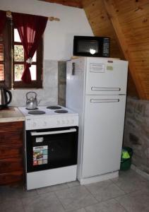 een keuken met een fornuis en een witte koelkast bij Alpinasmaquen in Puerto Quequén