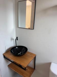 a bathroom with a black sink on a wooden table at Tiny House Campeche - Vista do Lampião in Florianópolis