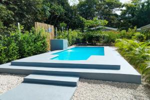 a swimming pool in a garden with stairs leading to it at BlueStone Residence in Brasilito +29 photos