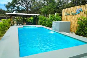 a swimming pool in a backyard with blue water at BlueStone Residence in Brasilito