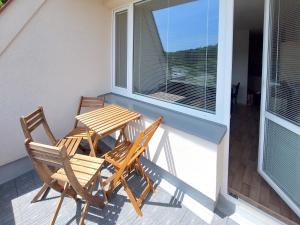 two chairs and a table on a balcony with a window at Apartmán Všemina 300 in Všemina