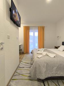 a bedroom with a bed with a tv on the wall at TOKIs apartmani in Mrkonjić Grad