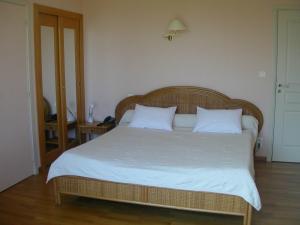 1 dormitorio con 1 cama grande con sábanas y almohadas blancas en L'Oustal du Lauragais, en Labastide-Beauvoir