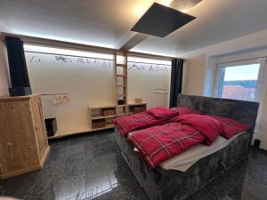 a bedroom with a bed with red sheets and a window at Zwischen Wald und Wiese in Lilach