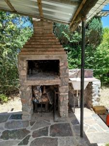 a stone fireplace under a roof with a staircase at Santa Mónica in Villa Giardino