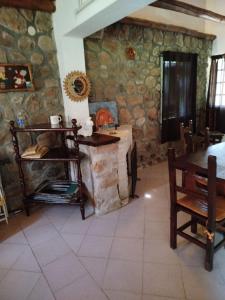 a living room with a stone wall with a fireplace at Santa Mónica in Villa Giardino +6 photos