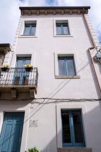 a white building with windows and a balcony at Dimora delle Storie in Tempio Pausania