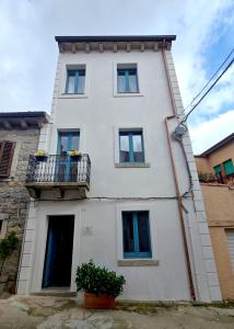 a white building with a balcony with flowers on it at Dimora delle Storie in Tempio Pausania