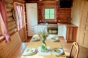 a kitchen with a table with a vase of flowers on it at Hüblerhütte in Lading