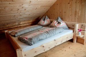 a bed in a log cabin with pillows on it at Hüblerhütte in Lading