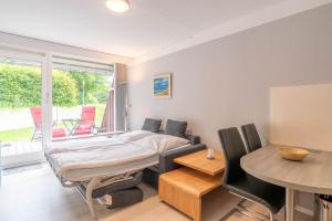 una camera da letto con un letto, un tavolo e delle sedie di Untenlinks-Kiel a Schilksee