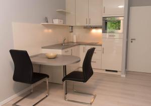 una piccola cucina con un tavolo e due sedie di Untenlinks-Kiel a Schilksee