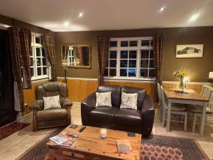 a living room with two chairs and a table at Cuckoo Cabin, Tyn Y Cwm in Scyborycoed +18 photos