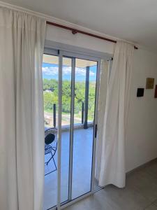a sliding glass door with a view of a balcony at Altos del Oeste in Villa Carlos Paz