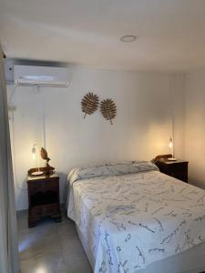 a bedroom with a bed and two side tables with lamps at Altos del Oeste in Villa Carlos Paz