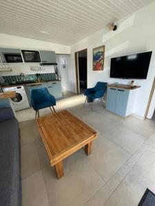a living room with a coffee table and blue chairs at Vanille-colibris Le Domaine Mannou in Sainte-Rose