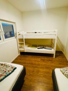 een kamer met twee stapelbedden en een raam bij Villa Lakeview Appartment in Leissigen