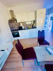 een keuken met twee paarse stoelen en een tafel in een kamer bij Villa Lakeview Appartment in Leissigen