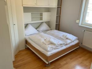 a small bedroom with a bed with white sheets and pillows at Marienkirche 2 - ABC336 in Wismar